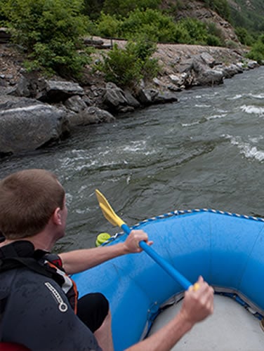 Man rafting on a rapid river