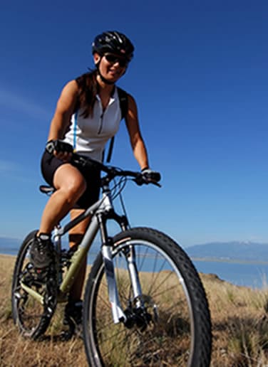 Woman riding her bike on a mountain trail